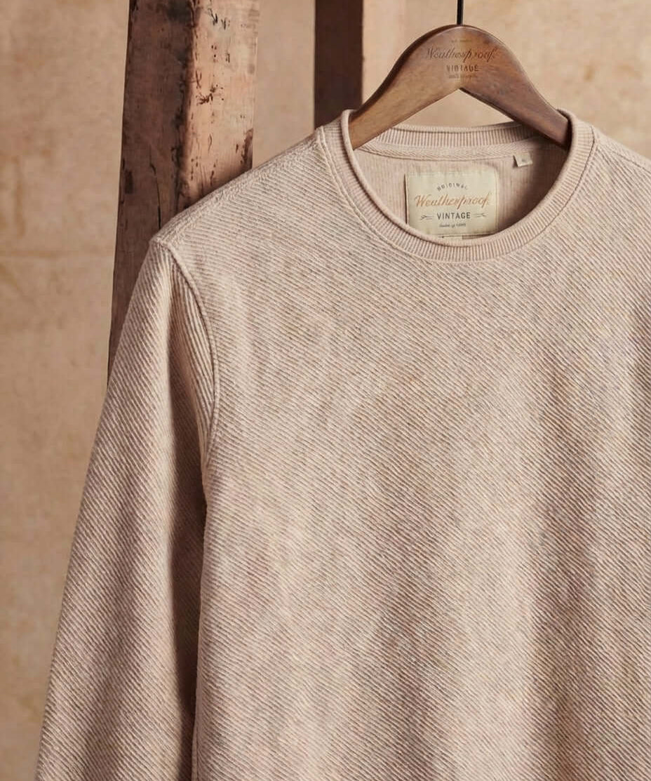 Twill Stonewash Sweater in Natural hanging on a wooden hanger, showcasing its soft, textured design.