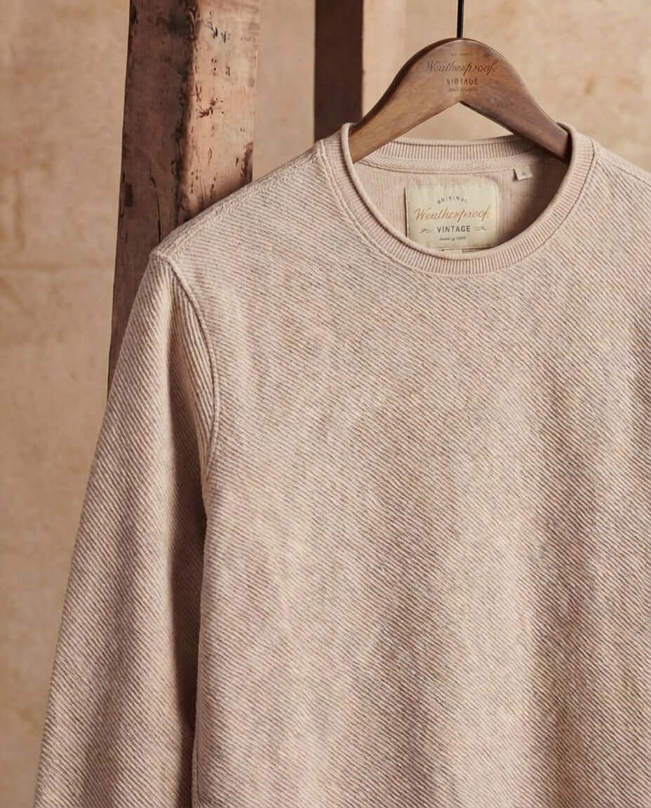 Twill Stonewash Sweater in Natural hanging on a wooden hanger, showcasing its soft, textured design.