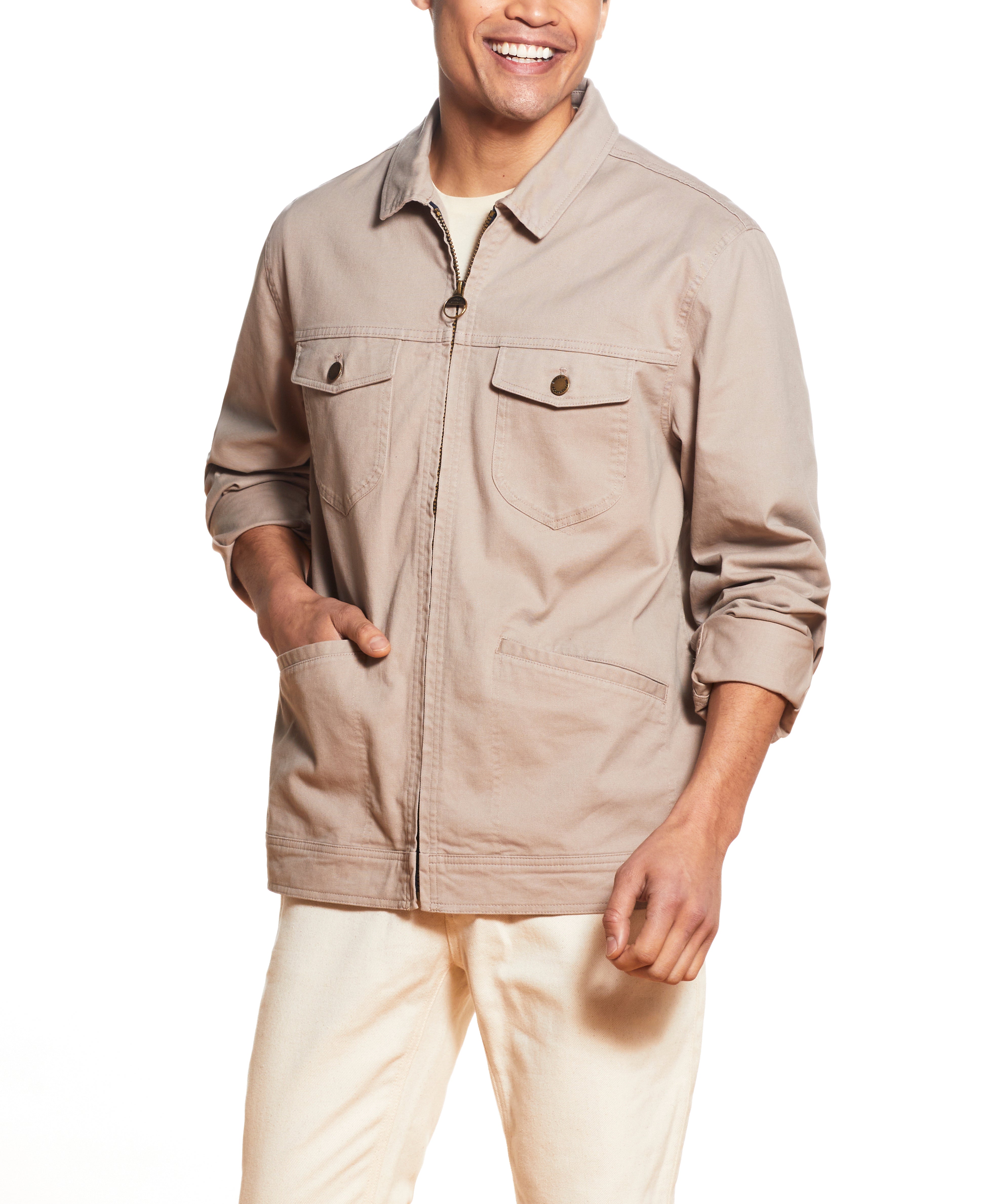 Man wearing a Twill Trucker In Vintage Khaki jacket with front buttoned patch pockets and slanted side welt pockets.
