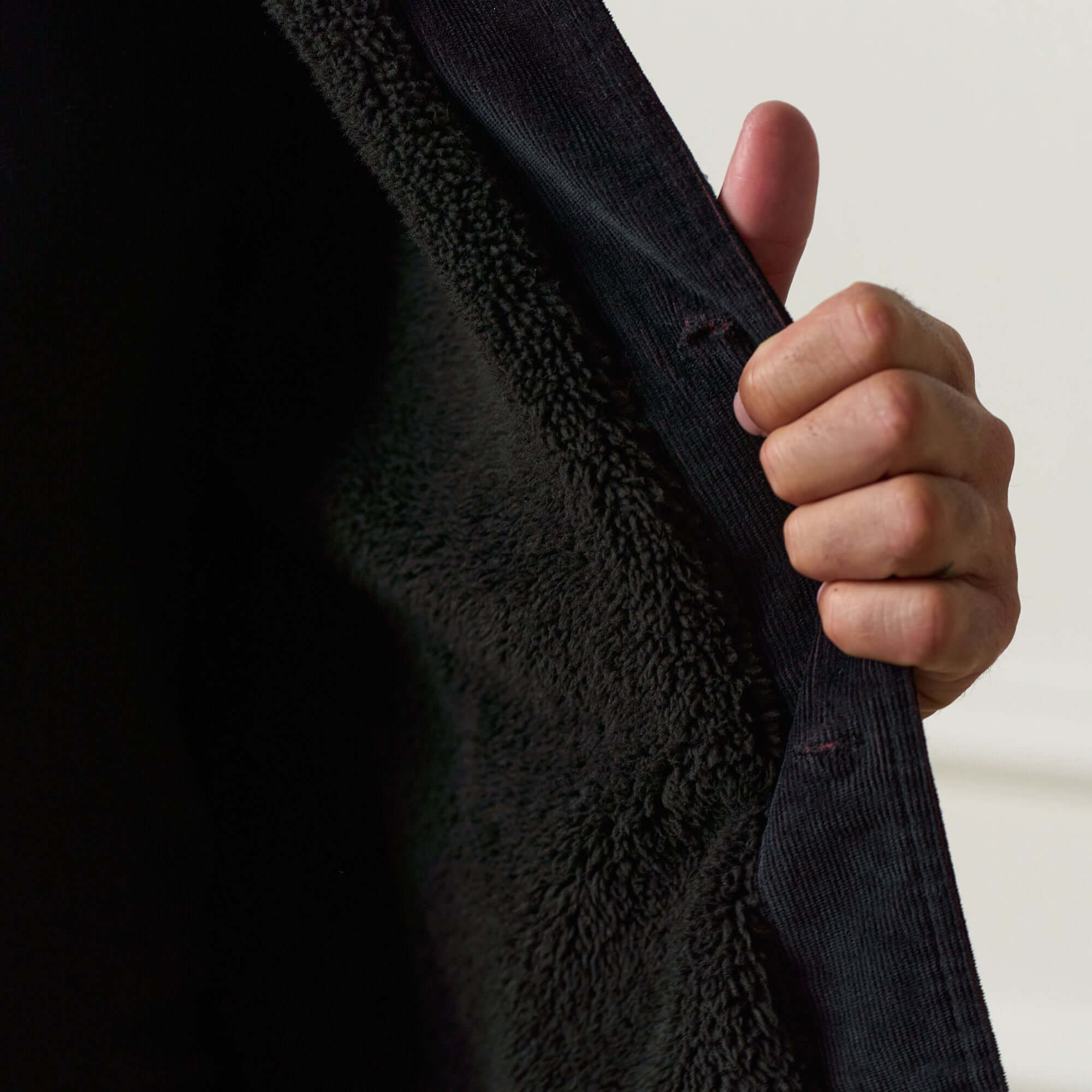 Two-Tone Cord Jacket in Black showcasing soft sherpa lining and corduroy texture detail.