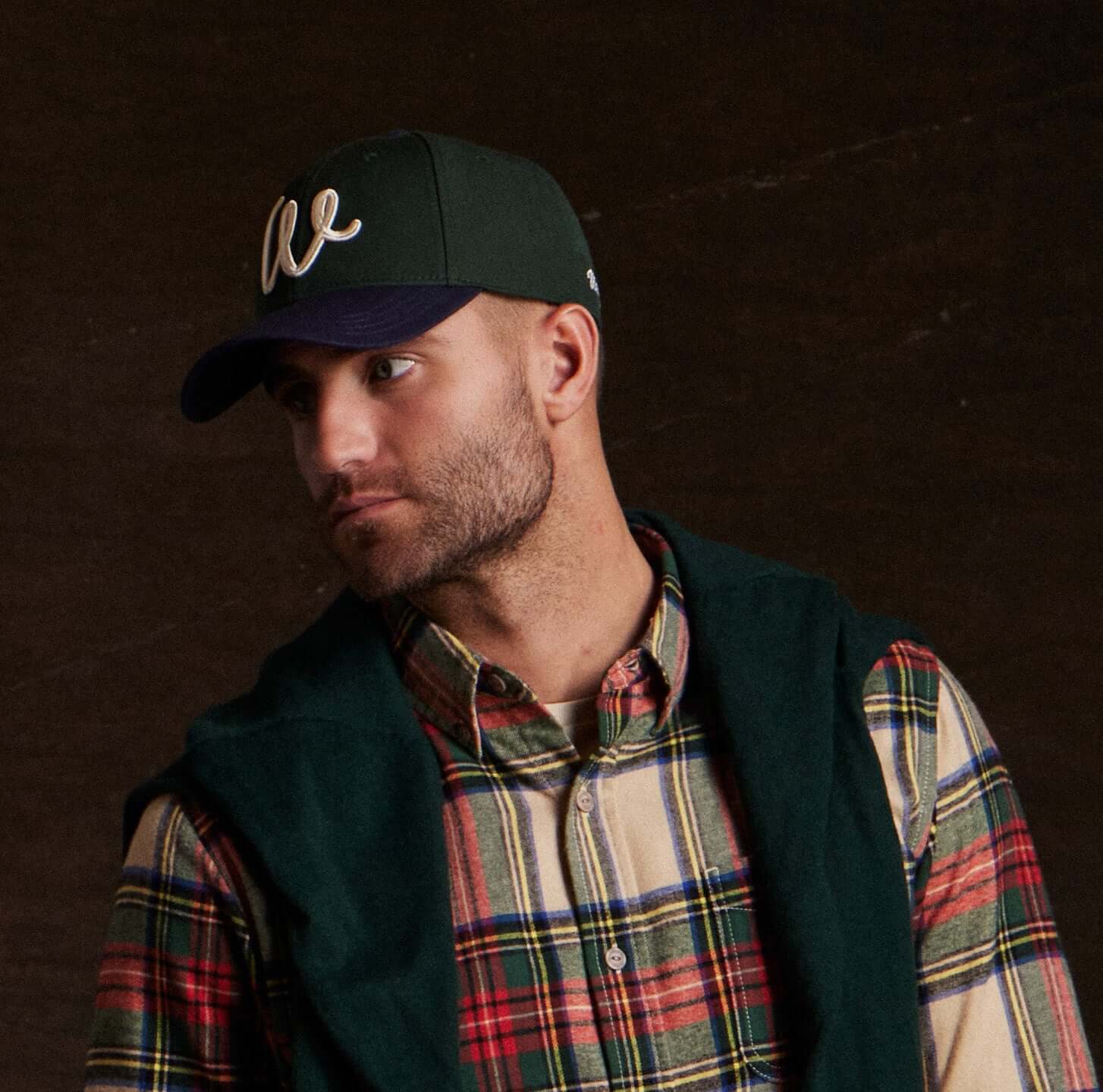 Man wearing a Two Tone Wool Hat in Dark Green and Navy with plaid shirt and green vest.