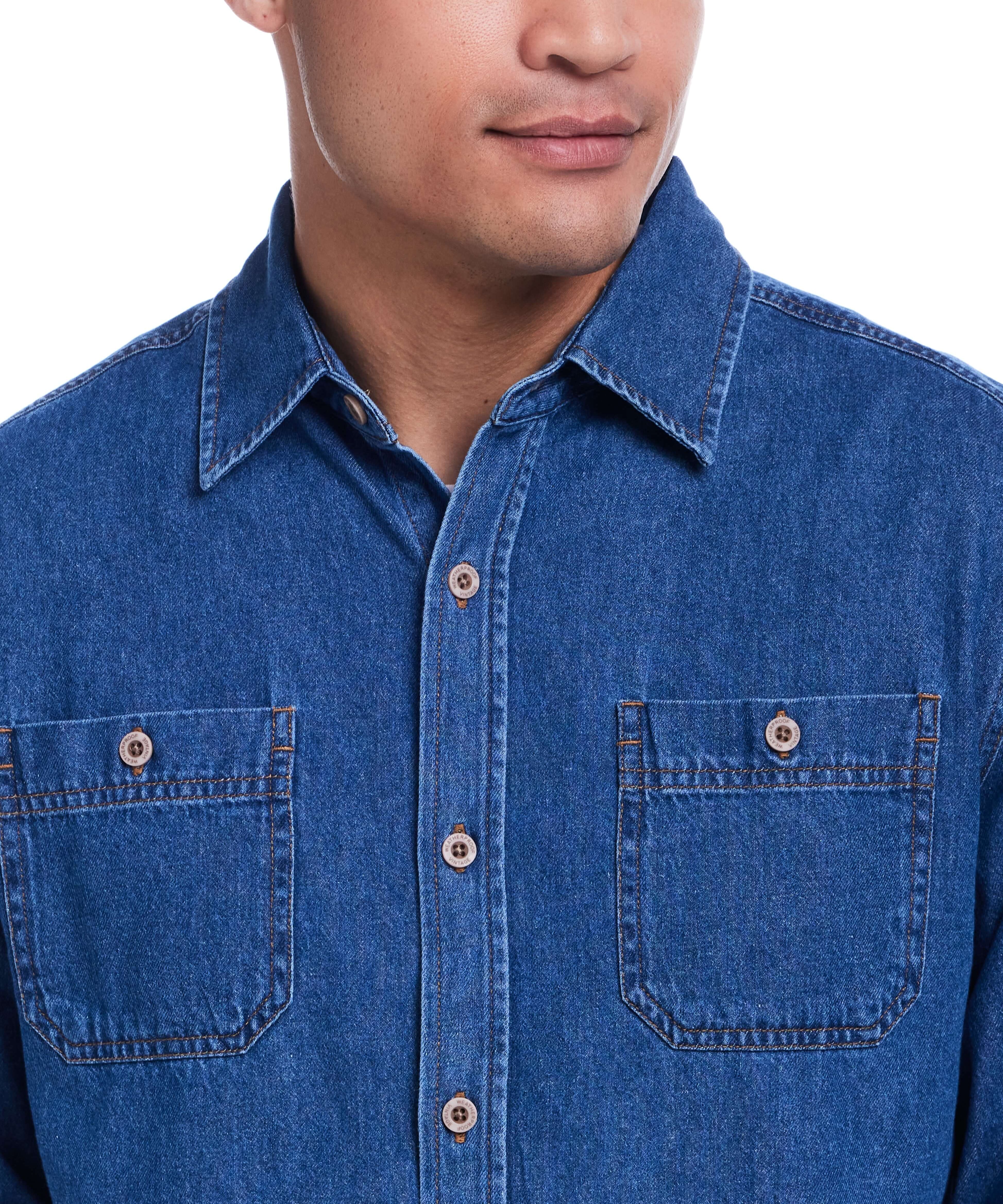 Close-up of a man wearing a Medium Indigo unlined denim overshirt, featuring a button-up design and chest pockets.