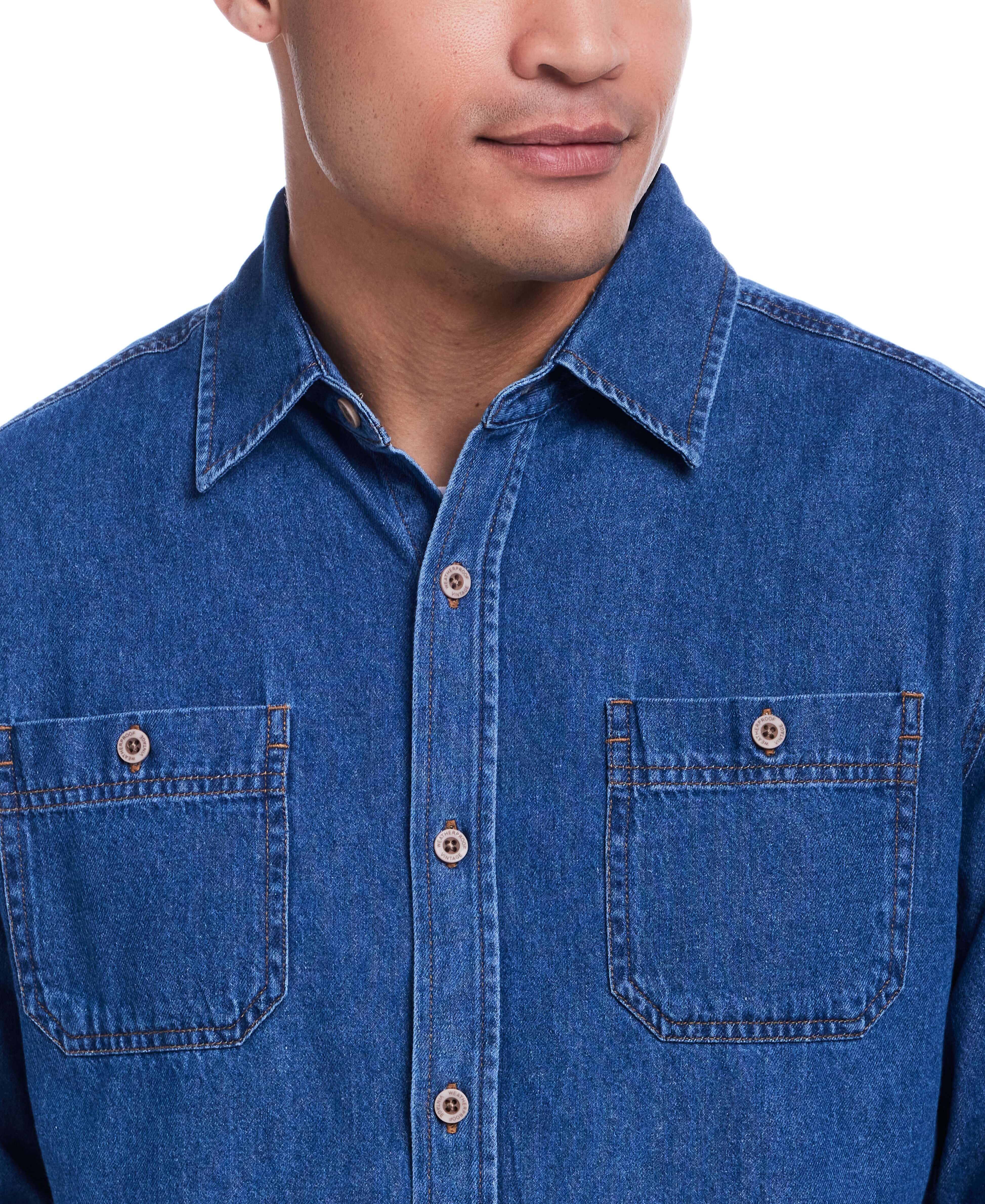 Close-up of a man wearing a Medium Indigo unlined denim overshirt, featuring a button-up design and chest pockets.