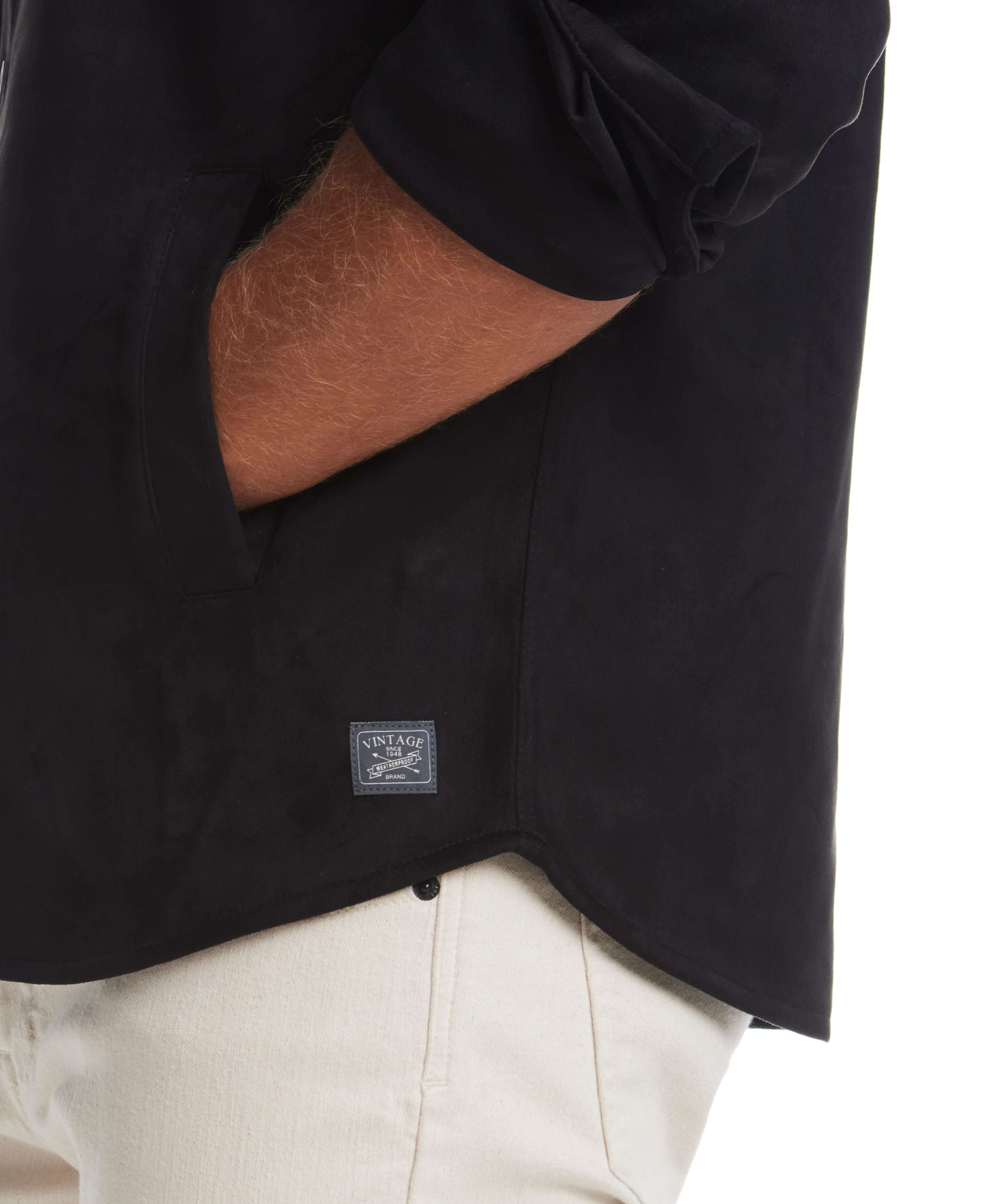Detail of unlined sueded shirt jacket in black, showcasing soft fabric and side pocket with label.
