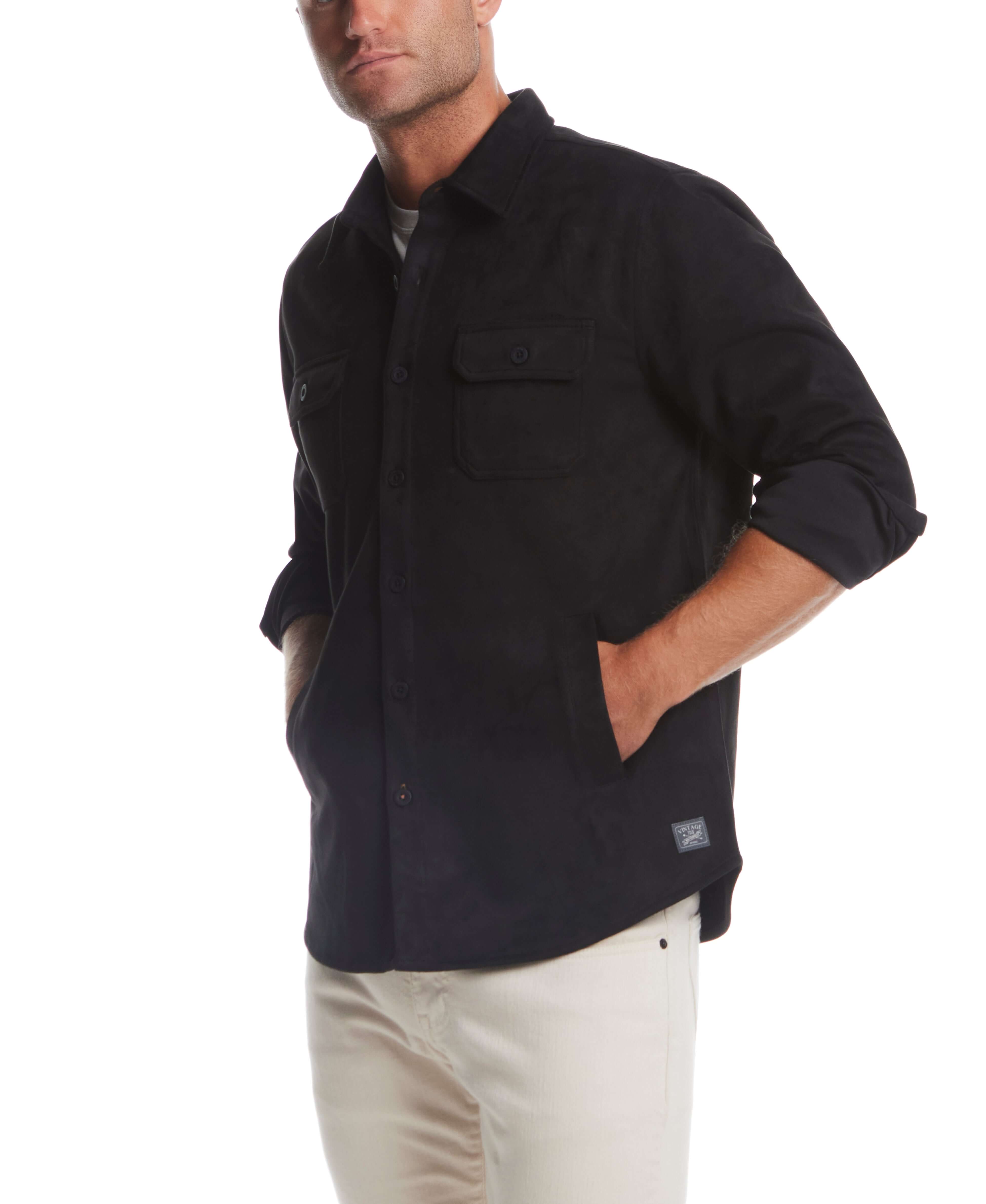 Man wearing an unlined sueded shirt jacket in black, featuring button flap chest pockets and side slash pockets.