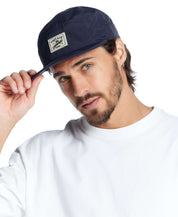 Man wearing a vintage navy jogger cap, showcasing its stylish design and logo.
