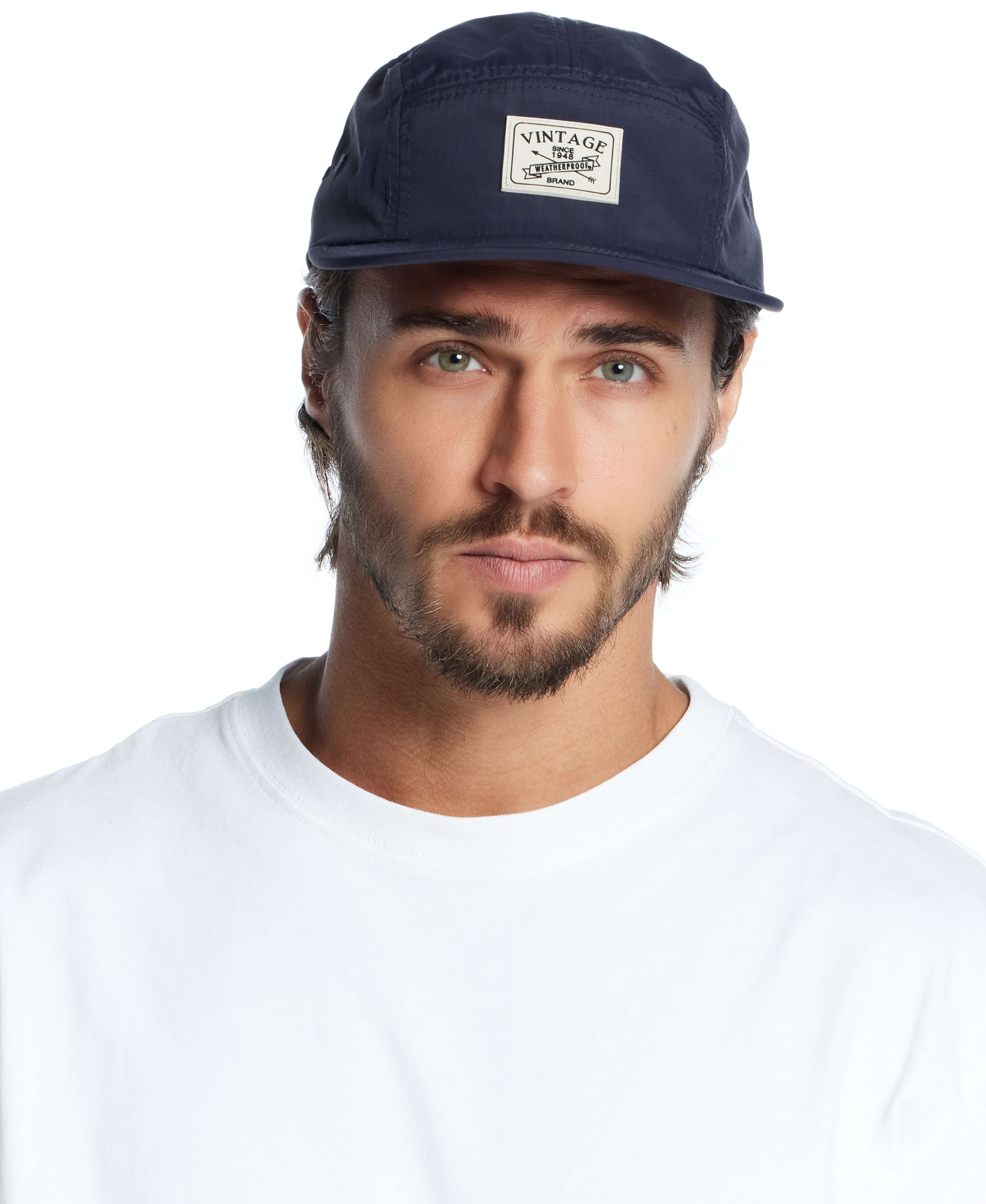 Vintage jogger cap in navy worn by a man, featuring a stylish label and casual white shirt.