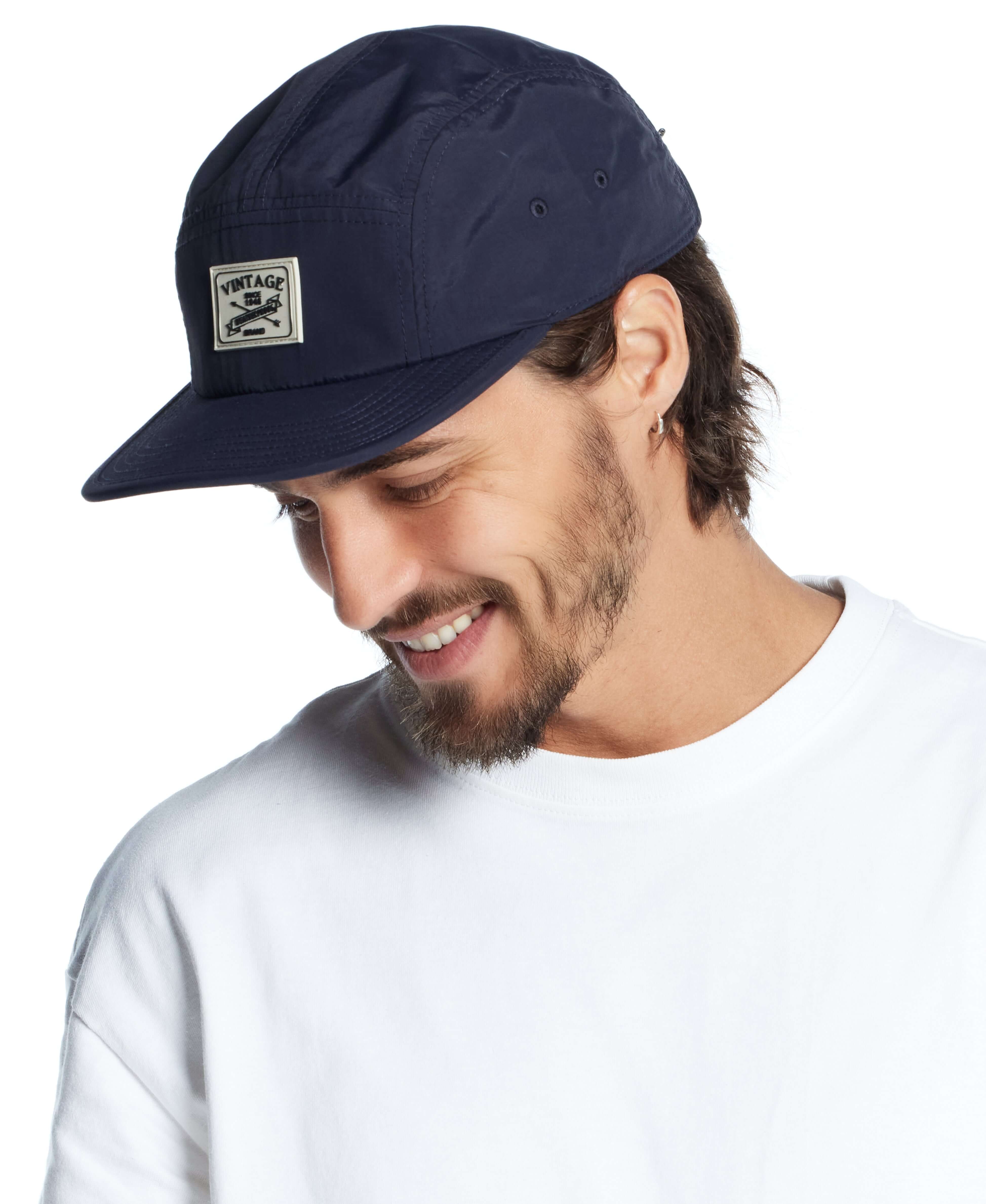 Vintage jogger cap in navy worn by a man, featuring a stylish logo patch and a casual look.