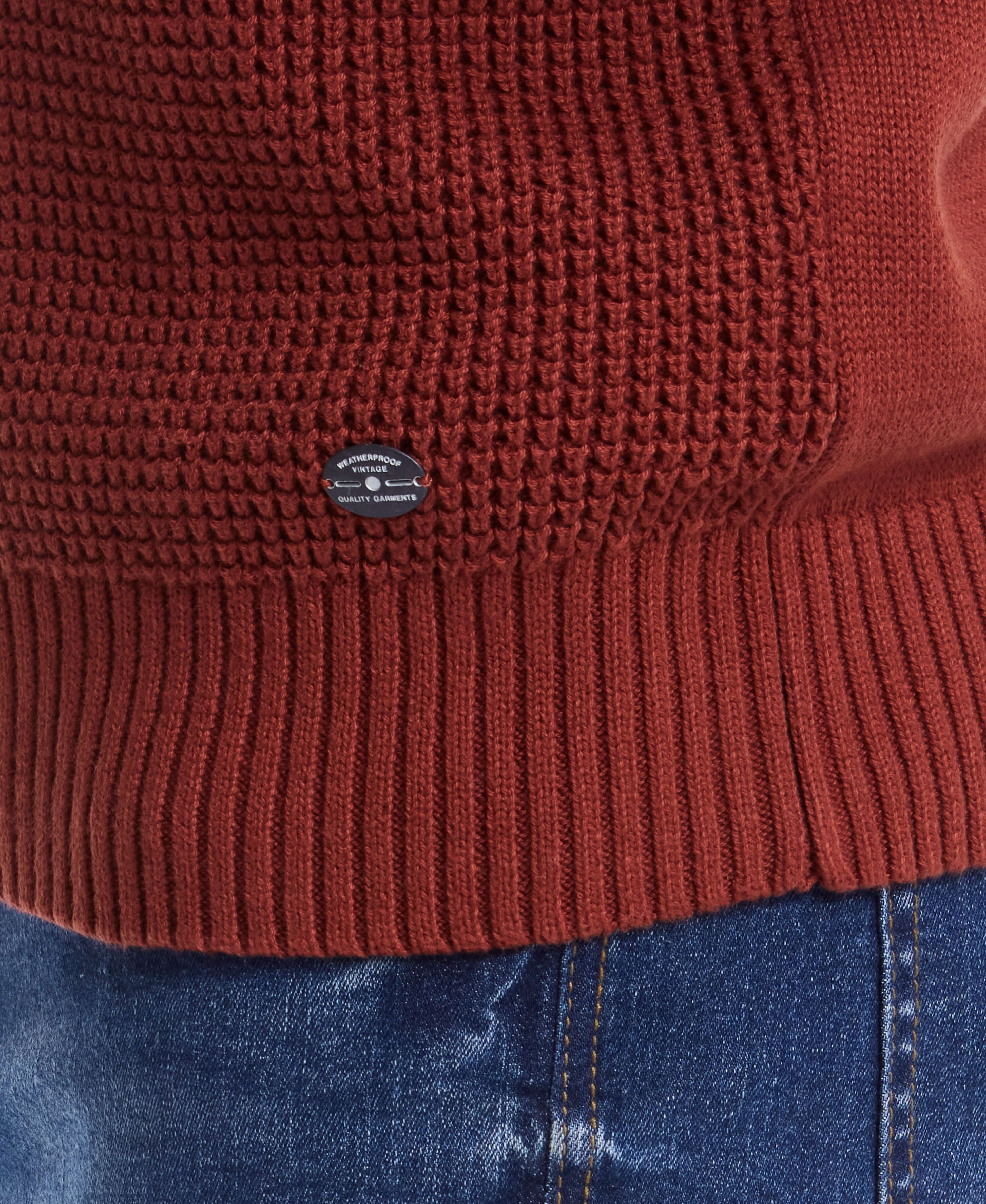 Close-up of a waffle texture 1/4 zip sweater in roasted russet, featuring a soft cotton material and ribbed hem.