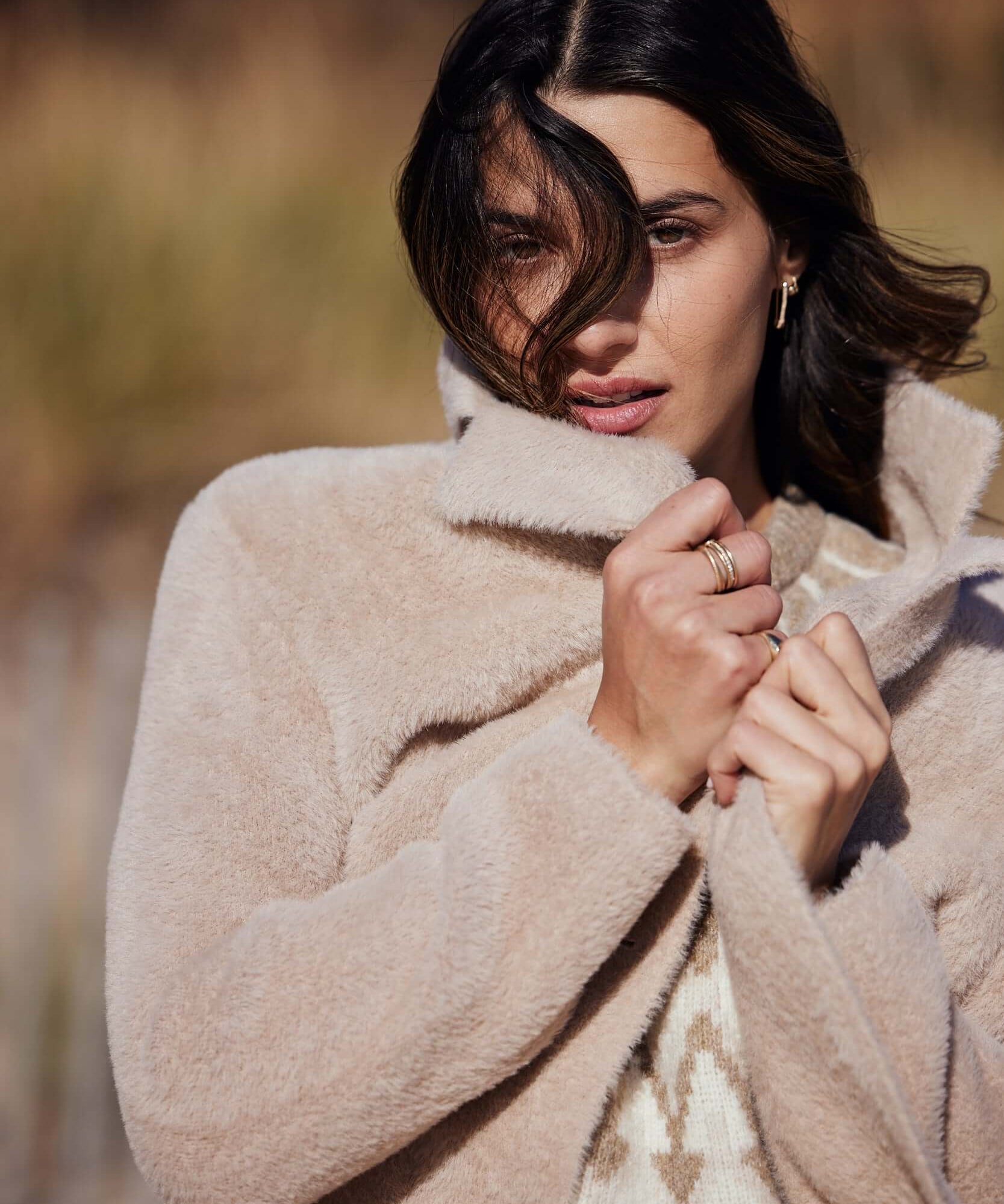 Woman wearing a plush apricot coatigan outdoors, showcasing its soft fabric and button closure.