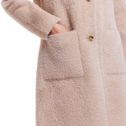Close-up of a women's plush coatigan in apricot, showcasing front patch pockets and soft fabric texture.