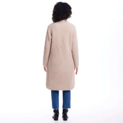 Back view of a woman wearing an apricot plush coatigan, featuring a cozy design and casual denim style.