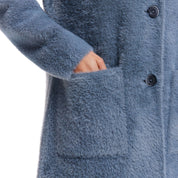 Close-up of a woman's hand reaching into the front patch pocket of a mid charcoal plush coatigan, showcasing its soft fabric.