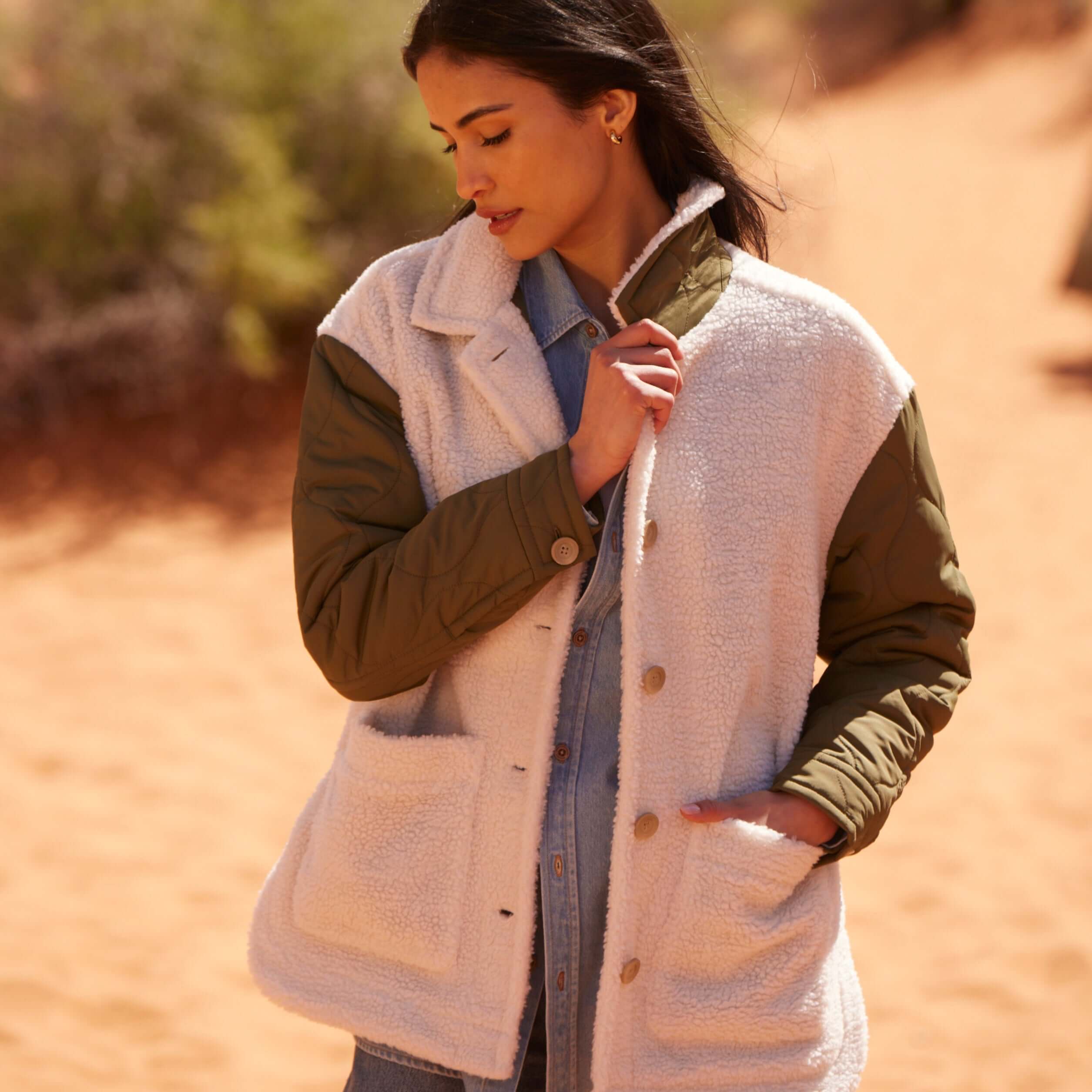 Woman in a cozy quilted mixed media jacket with faux shearling, perfect for stylish warmth in outdoor settings.