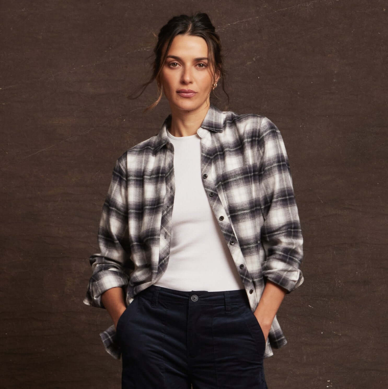 Model wearing a black and white plaid women's stretch flannel with notch V-neck and rolled sleeves.