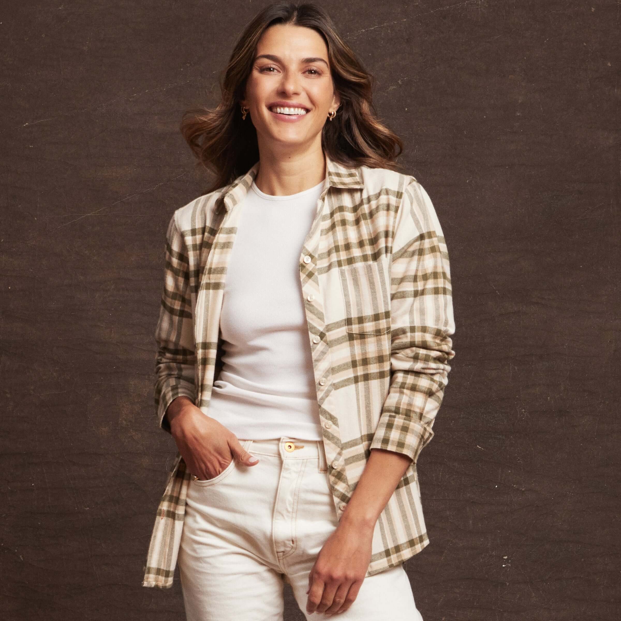 Smiling woman wearing a lightweight flannel shirt with plaid pattern over a white top, styled for a casual look.