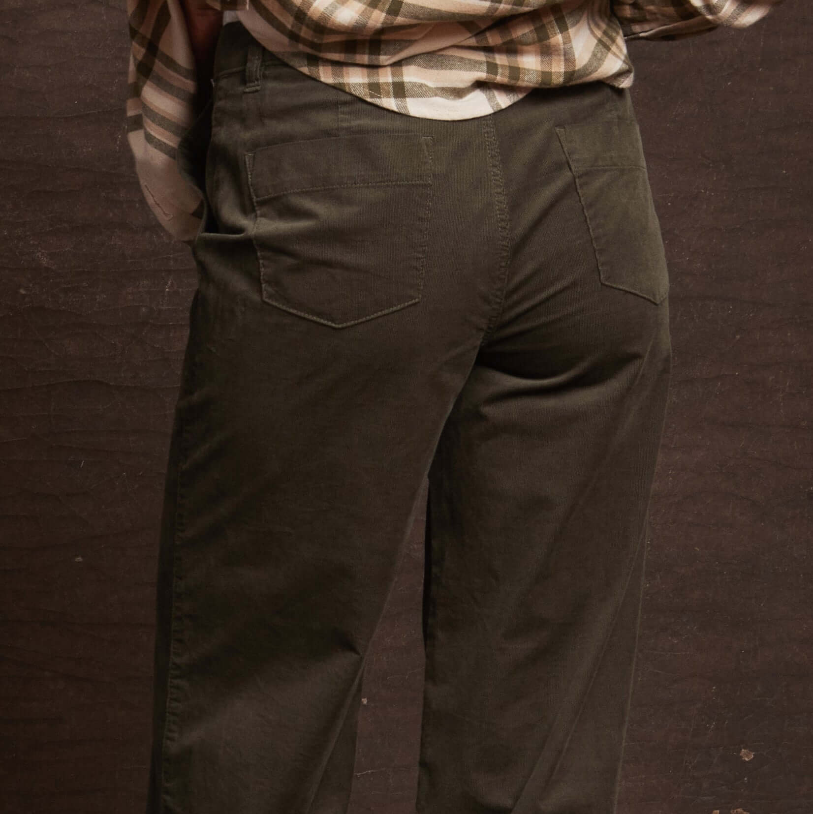 Back view of women's wide leg corduroy pant in olive, showcasing utility patch pockets and relaxed fit.