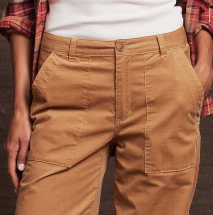 Close-up of women's tan wide leg corduroy pants showcasing front utility pockets and button detail.