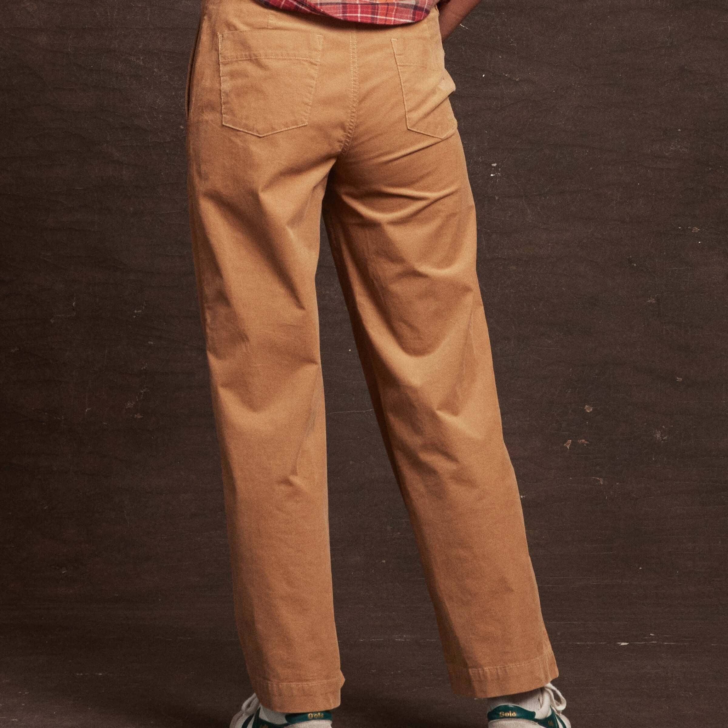 Back view of women's tan wide leg corduroy pants showcasing patch pockets and relaxed fit.