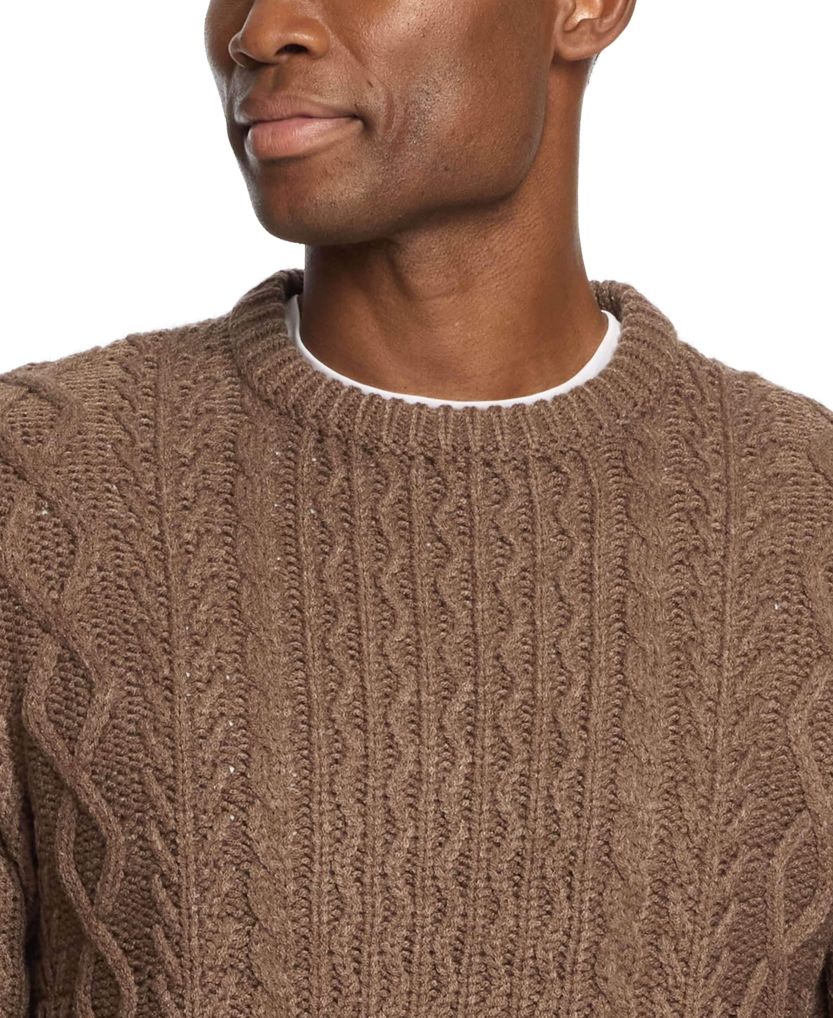 Model wearing a brown Zig Zag Cable Knit Crew sweater, showcasing its textured knit design and round neckline.